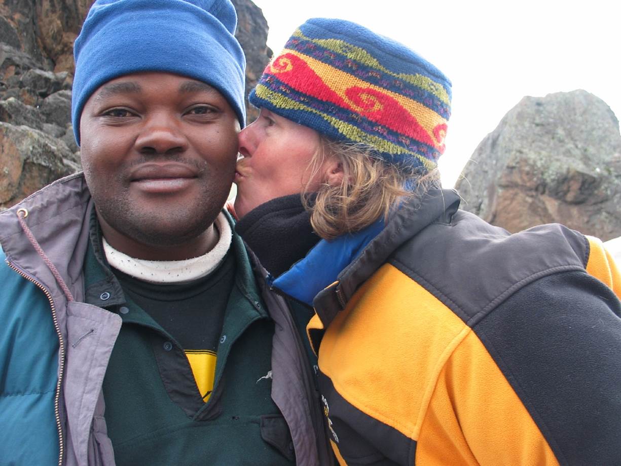 Susan Purvis captivates as a keynote speaker as she kisses a guide on Mt Kilimanjaro on the cheek